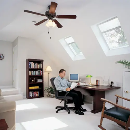 Man sitting in an office with skylights.
